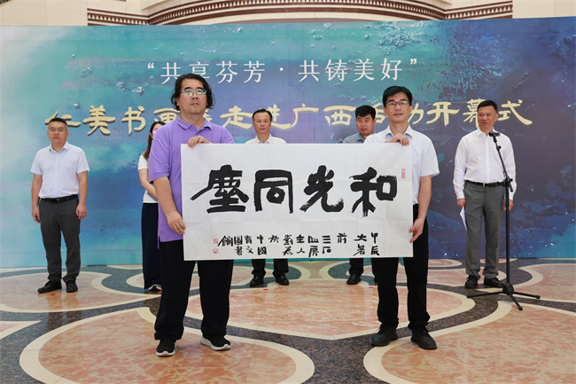 图为中国残疾人事业新闻宣传促进会向广西民族博物馆赠送墨宝